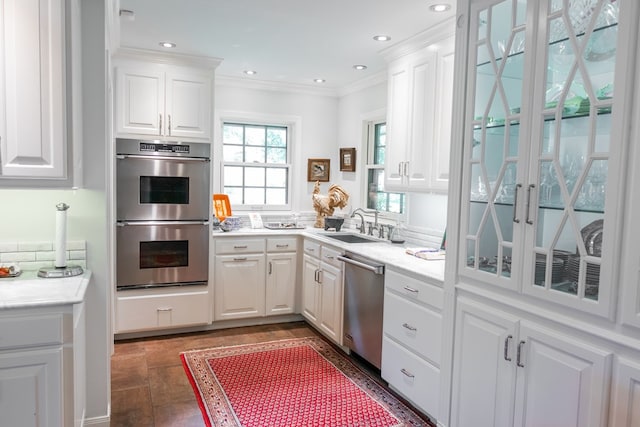 kitchen featuring crown molding, appliances with stainless steel finishes, sink, and white cabinets