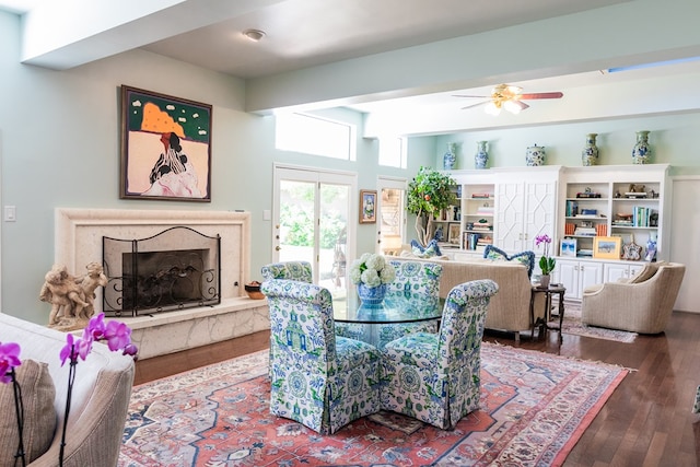 dining area with hardwood / wood-style flooring, ceiling fan, and a high end fireplace