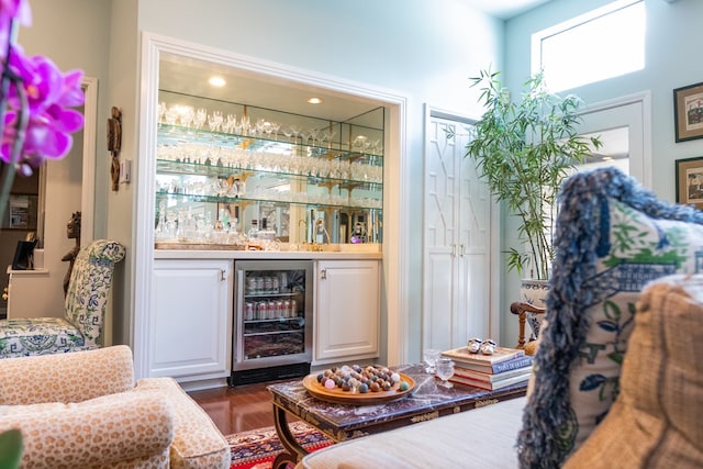 bar with white cabinetry, dark hardwood / wood-style floors, and beverage cooler