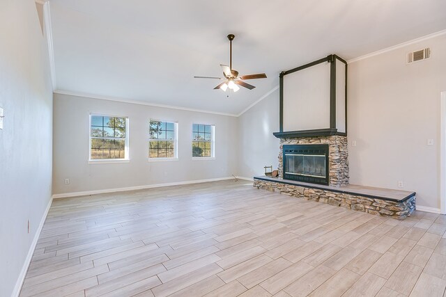 unfurnished living room with crown molding, a stone fireplace, light hardwood / wood-style flooring, and ceiling fan