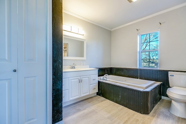 bathroom with toilet, crown molding, wood-type flooring, vanity, and a bathing tub