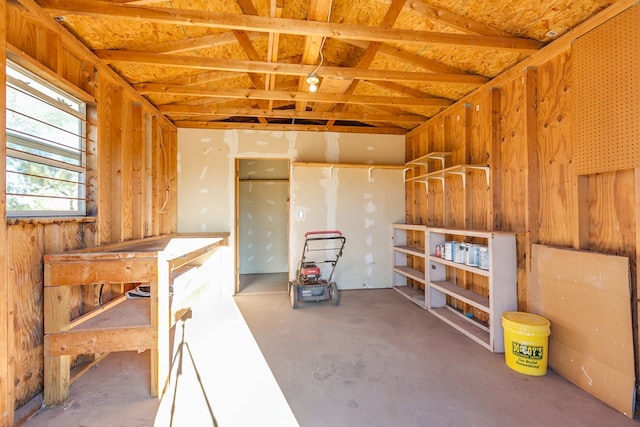 interior space featuring concrete flooring and wooden walls