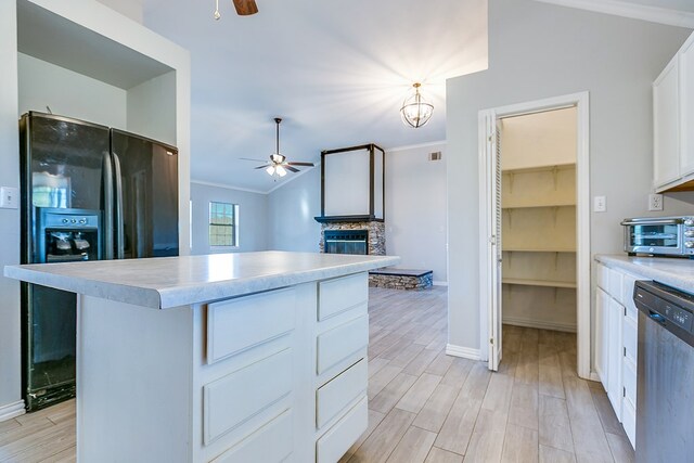 kitchen with dishwasher, white cabinets, a center island, ceiling fan, and black fridge