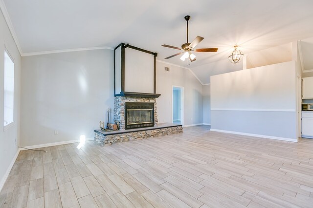 unfurnished living room with vaulted ceiling, a stone fireplace, ceiling fan, crown molding, and light wood-type flooring