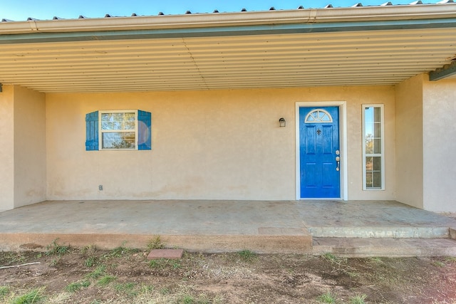 view of exterior entry featuring a patio area