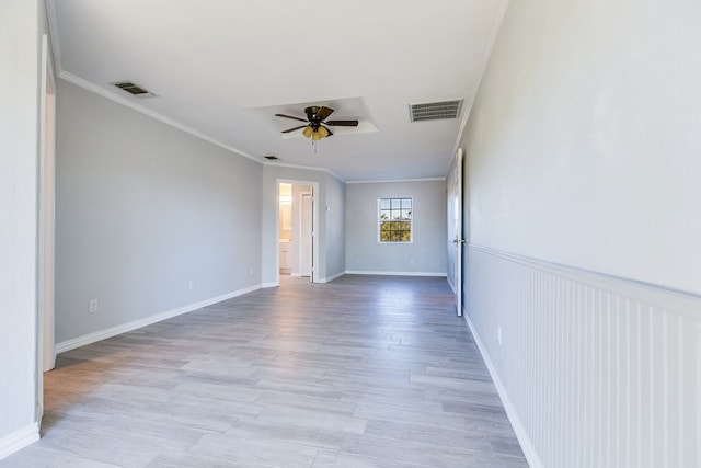 empty room with ornamental molding, ceiling fan, and light wood-type flooring