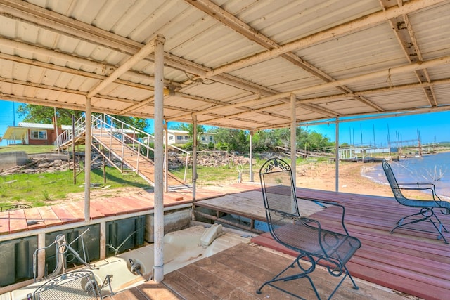 wooden terrace featuring a water view and a floating dock