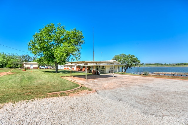 view of front of home with a water view, a front lawn, and a carport