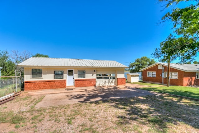 view of front facade with driveway, a garage, brick siding, fence, and a front lawn