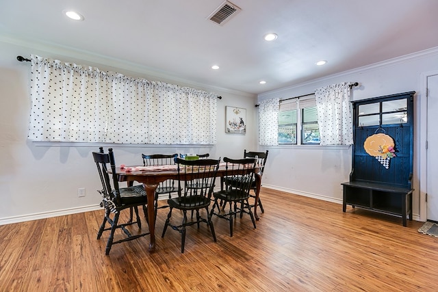 dining room with baseboards, ornamental molding, wood finished floors, and visible vents