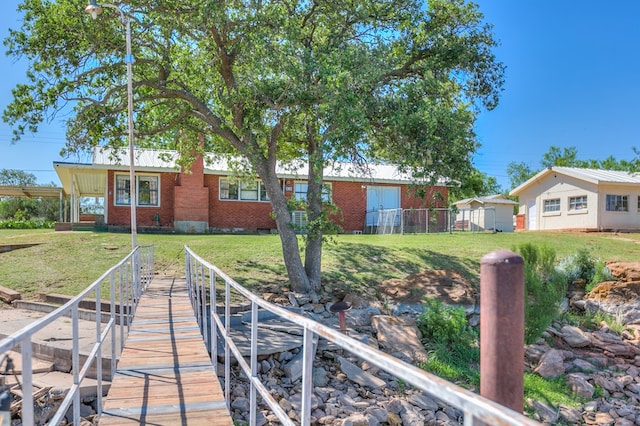 view of dock with a lawn and fence