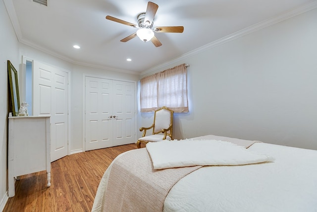 bedroom with a ceiling fan, crown molding, wood finished floors, a closet, and recessed lighting
