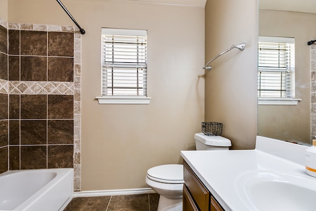 full bathroom featuring tiled shower / bath combo, vanity, tile patterned floors, and toilet