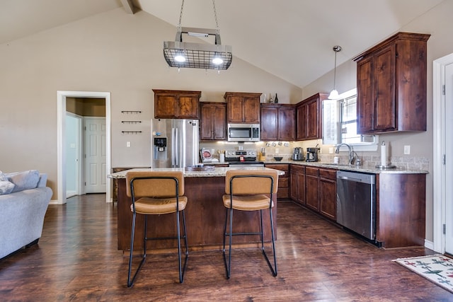 kitchen featuring sink, dark wood-type flooring, hanging light fixtures, stainless steel appliances, and a center island