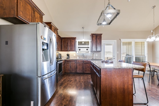 kitchen featuring pendant lighting, stainless steel appliances, a kitchen breakfast bar, and a center island