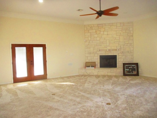 unfurnished living room featuring french doors, carpet flooring, ornamental molding, and a fireplace