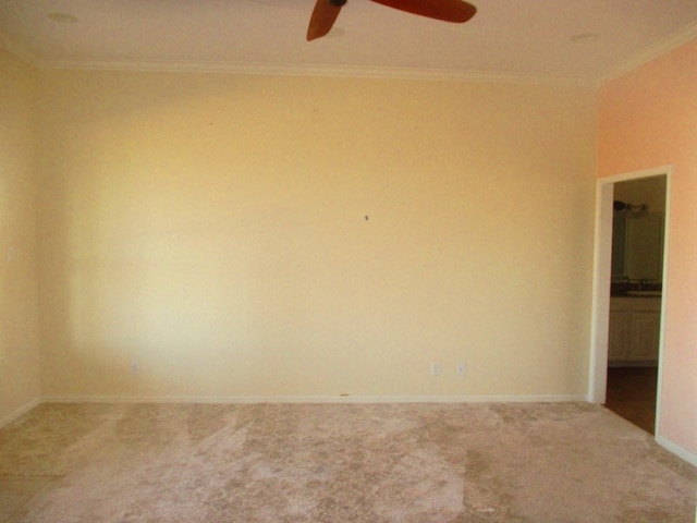 carpeted spare room featuring crown molding and ceiling fan