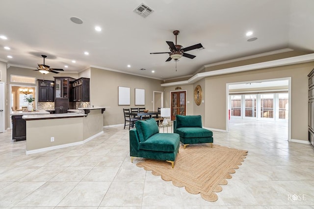 tiled living room with ornamental molding and ceiling fan