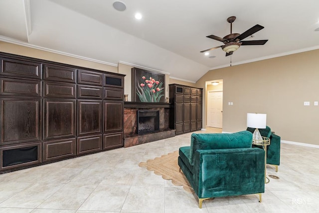 tiled living room featuring lofted ceiling, ornamental molding, a premium fireplace, and ceiling fan