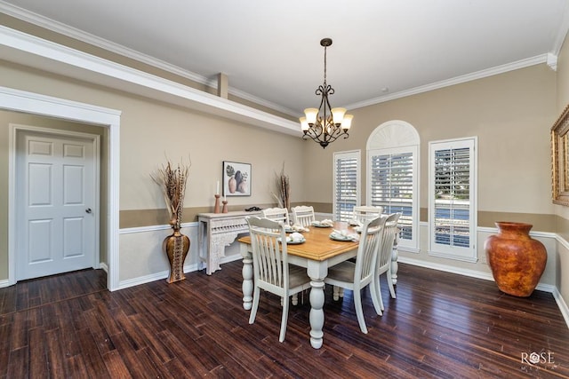 dining space with dark hardwood / wood-style flooring, ornamental molding, and a chandelier