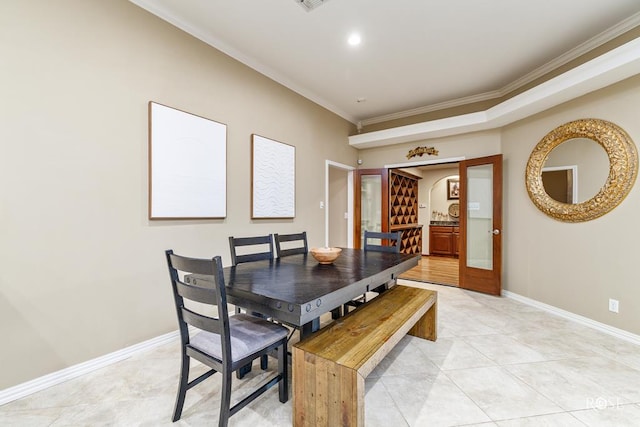 dining space featuring ornamental molding and light tile patterned floors