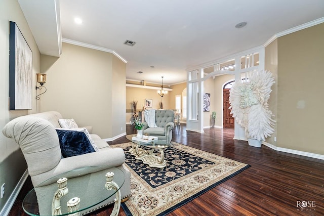 living room with crown molding, hardwood / wood-style floors, and an inviting chandelier