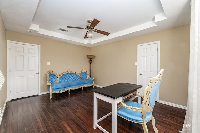 office area featuring dark wood-type flooring, ceiling fan, and a tray ceiling