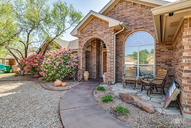 entrance to property featuring brick siding