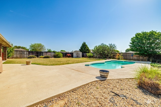 view of pool featuring an outdoor structure, a fenced backyard, a yard, a storage shed, and a patio