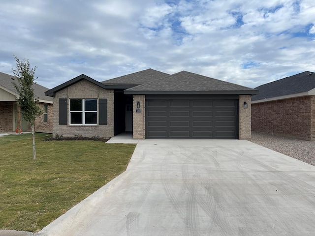 view of front of property featuring a garage and a front lawn