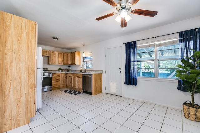 kitchen featuring sink, light tile patterned floors, ceiling fan, appliances with stainless steel finishes, and decorative light fixtures