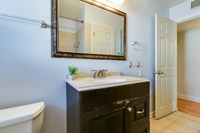 bathroom with vanity, a shower, tile patterned floors, and toilet