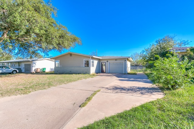 ranch-style home with a garage and a front lawn