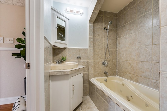 bathroom featuring vanity, tile patterned floors, and tiled shower / bath