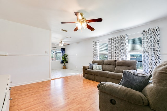 living room with ceiling fan, a wealth of natural light, and light hardwood / wood-style floors