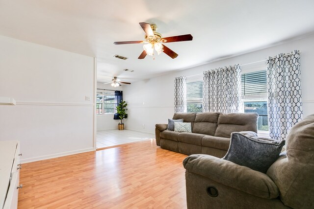 living room with ceiling fan, a wealth of natural light, and light hardwood / wood-style floors