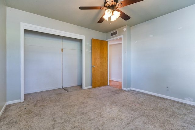 unfurnished bedroom featuring ceiling fan, light colored carpet, and a closet