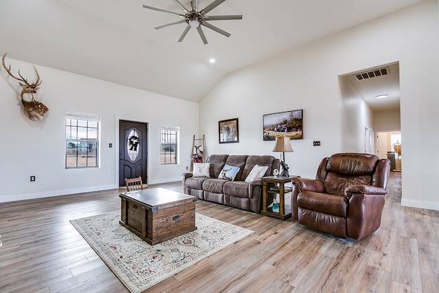 living room featuring vaulted ceiling, light hardwood / wood-style floors, and ceiling fan