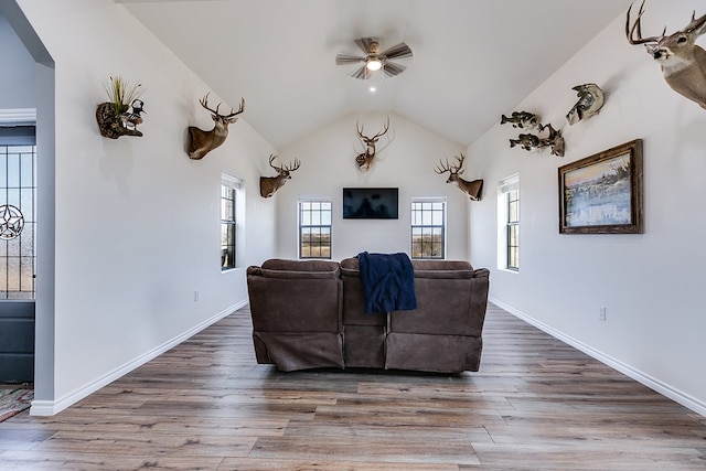 living room with wood-type flooring, vaulted ceiling, and ceiling fan