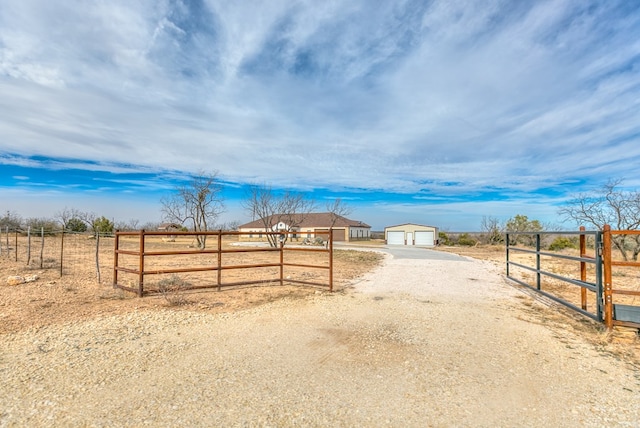 view of yard with an outbuilding, a garage, and a rural view