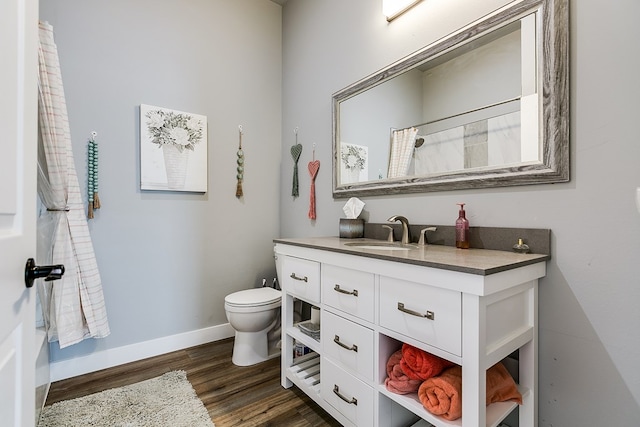 bathroom featuring vanity, toilet, curtained shower, and hardwood / wood-style floors