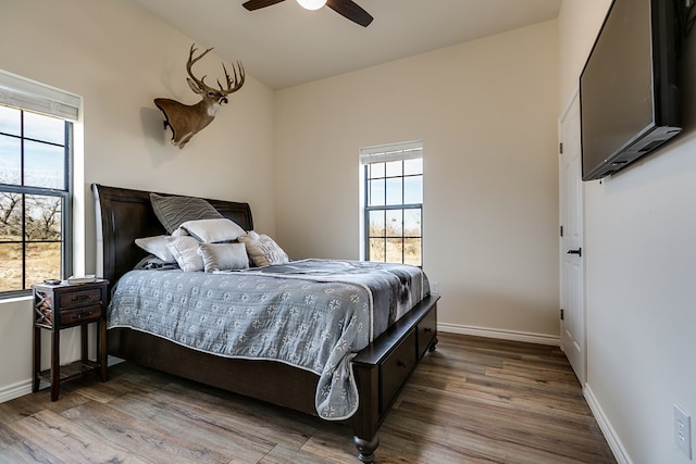 bedroom with multiple windows, vaulted ceiling, hardwood / wood-style floors, and ceiling fan