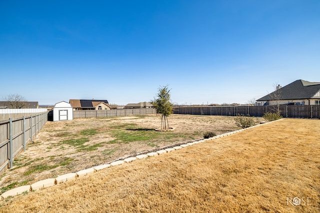 view of yard with a fenced backyard, an outdoor structure, and a shed