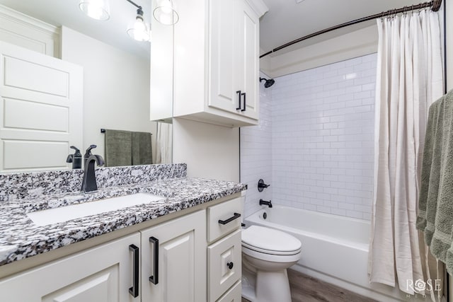 full bathroom featuring toilet, wood finished floors, shower / tub combo with curtain, and vanity