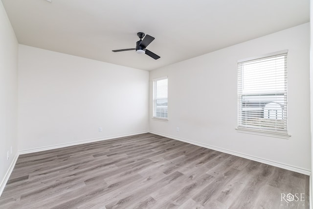 unfurnished room featuring ceiling fan, baseboards, and wood finished floors