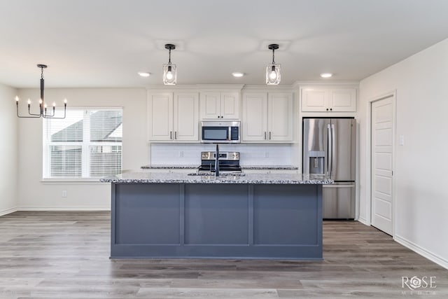 kitchen featuring stainless steel appliances, light stone counters, backsplash, and white cabinets