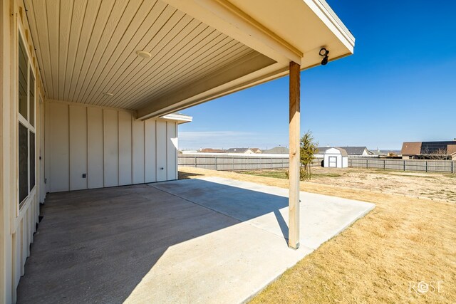 view of patio / terrace with fence, an outdoor structure, and a storage unit