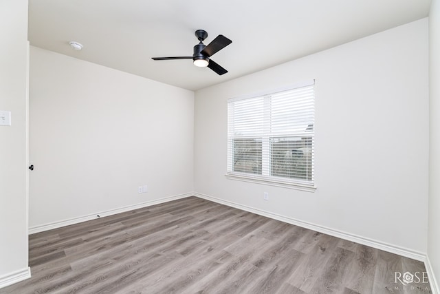 unfurnished room featuring a ceiling fan, baseboards, and wood finished floors