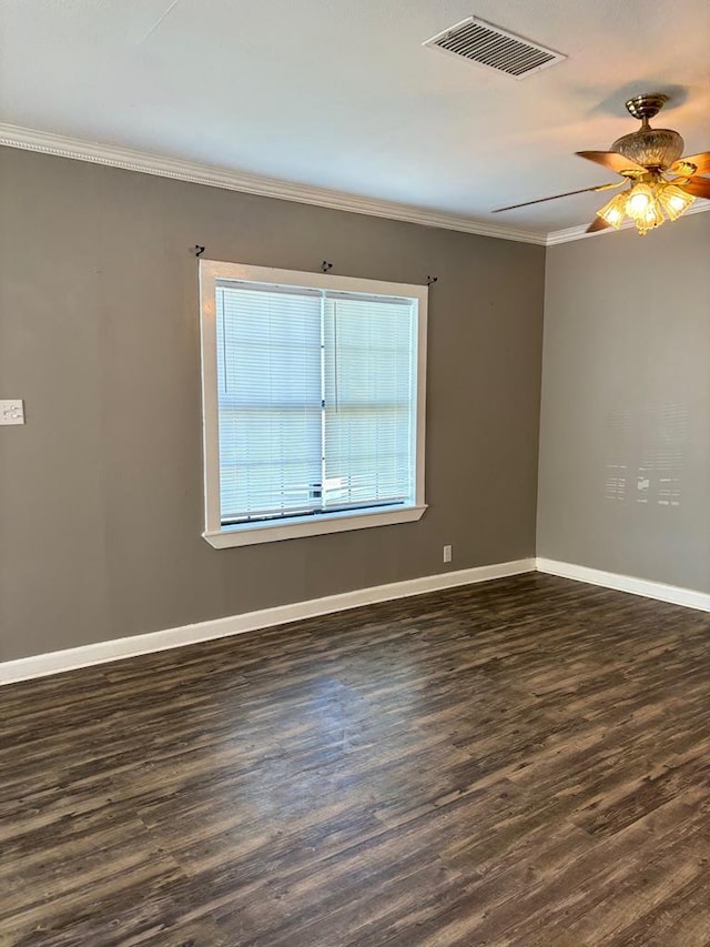 spare room featuring dark wood-type flooring, ornamental molding, and ceiling fan