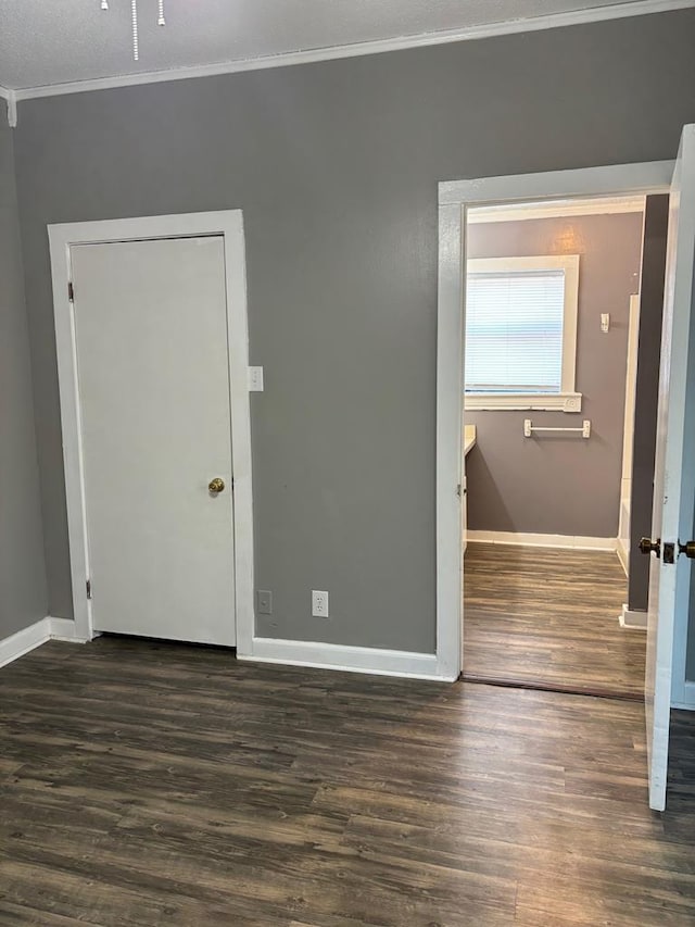 unfurnished room with crown molding and dark hardwood / wood-style flooring